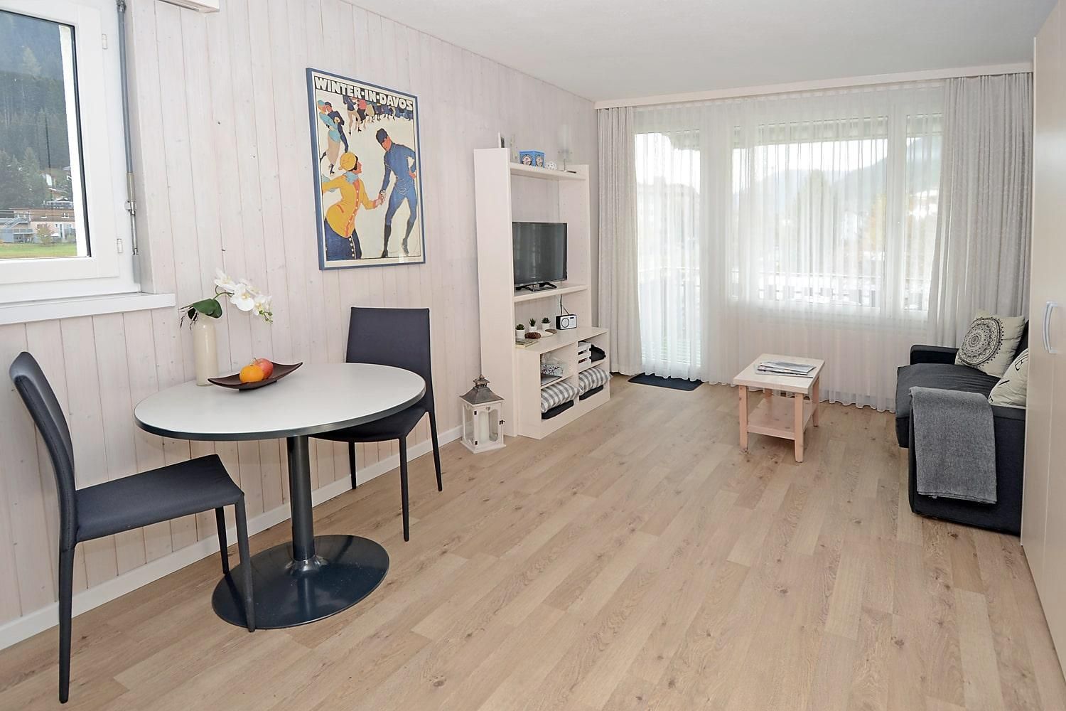 Wohnbereich mit Tisch und Sofa - Ferienwohnung Studio 25 - Haus Green - Davos Platz